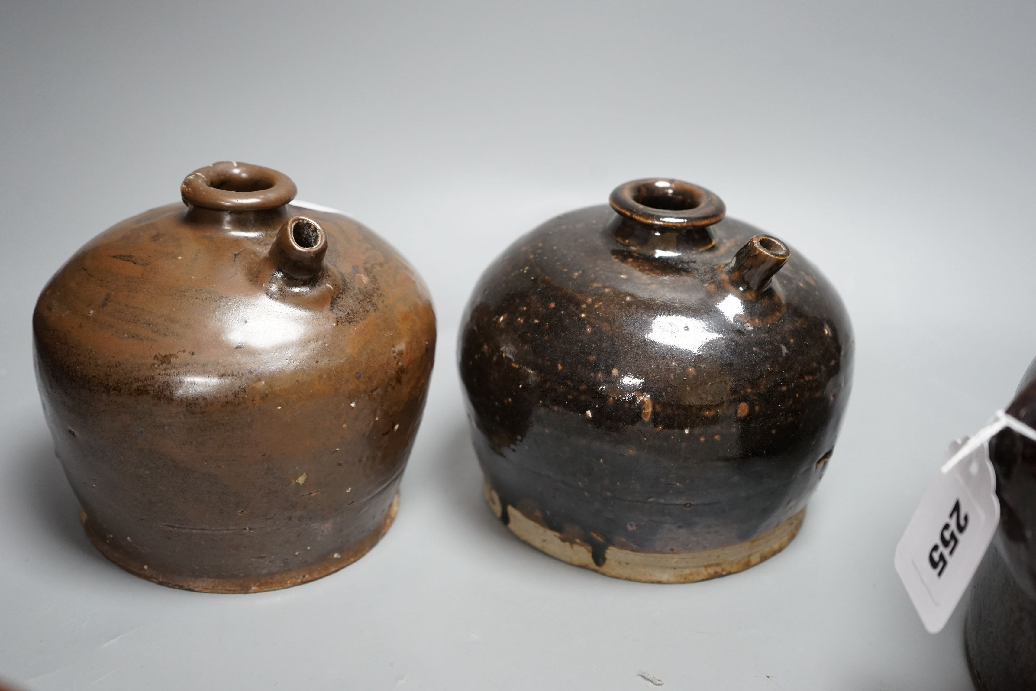 Two 19th century Chinese tenmoku glazed soy sauce jars, a similar jar and a pouring vessel, largest 14cm tall